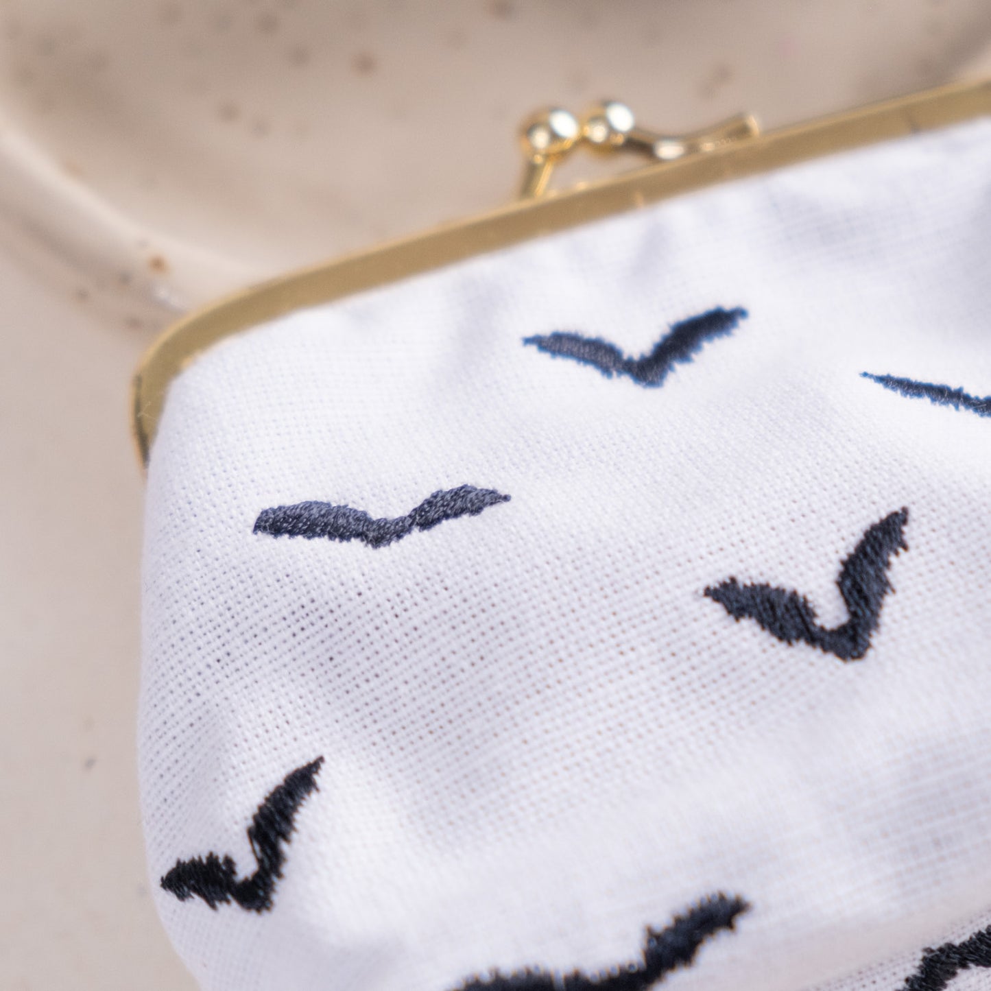 Torbica s kovinskim zapiranjem in izvezenimi netopirji