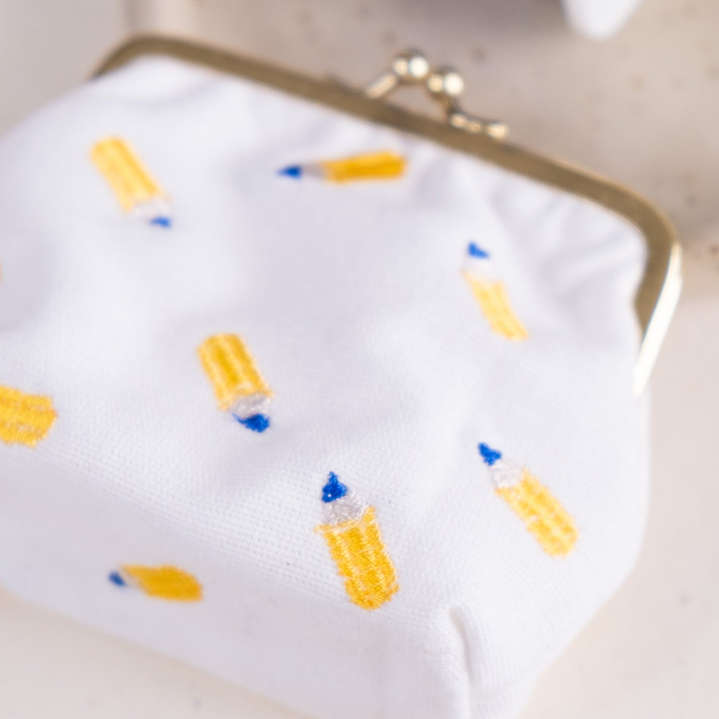 Torbica s kovinskim zapiranjem in izvezenimi svinčniki