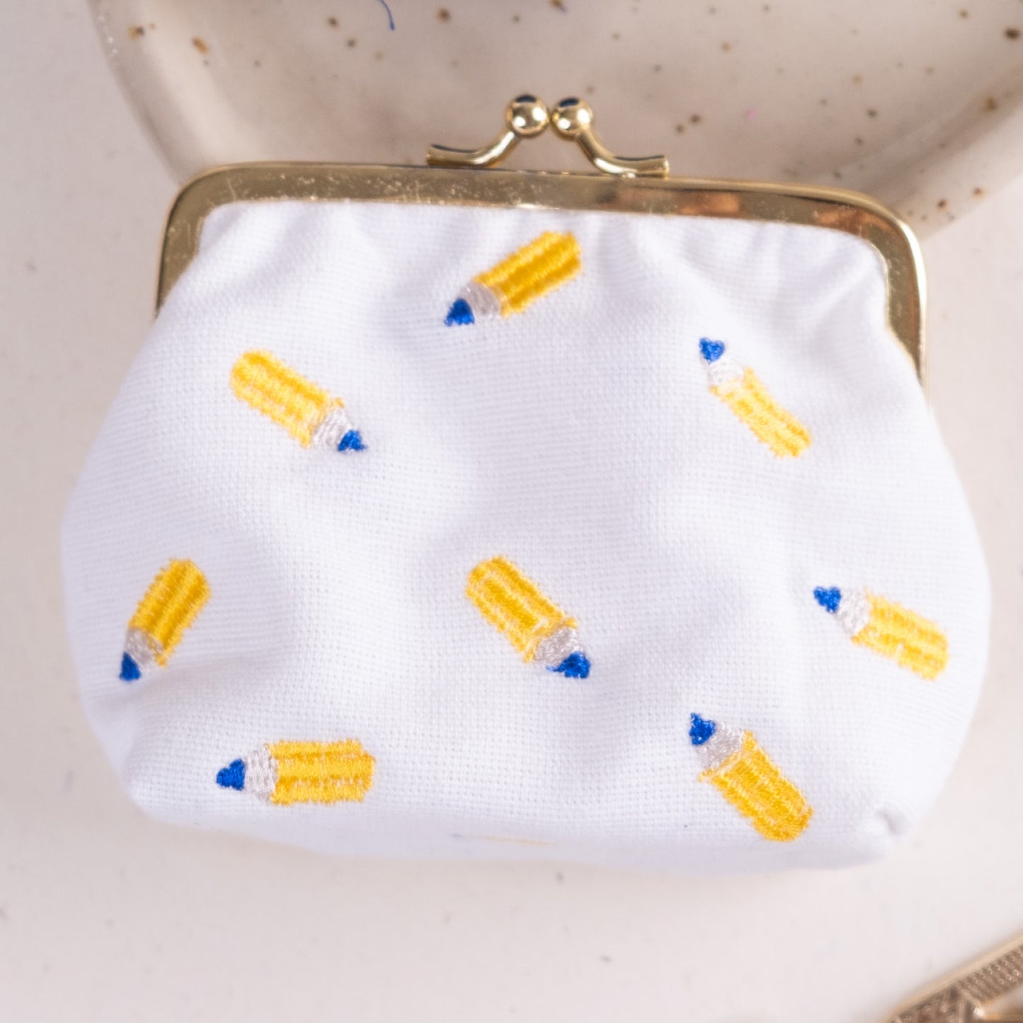 Torbica s kovinskim zapiranjem in izvezenimi svinčniki