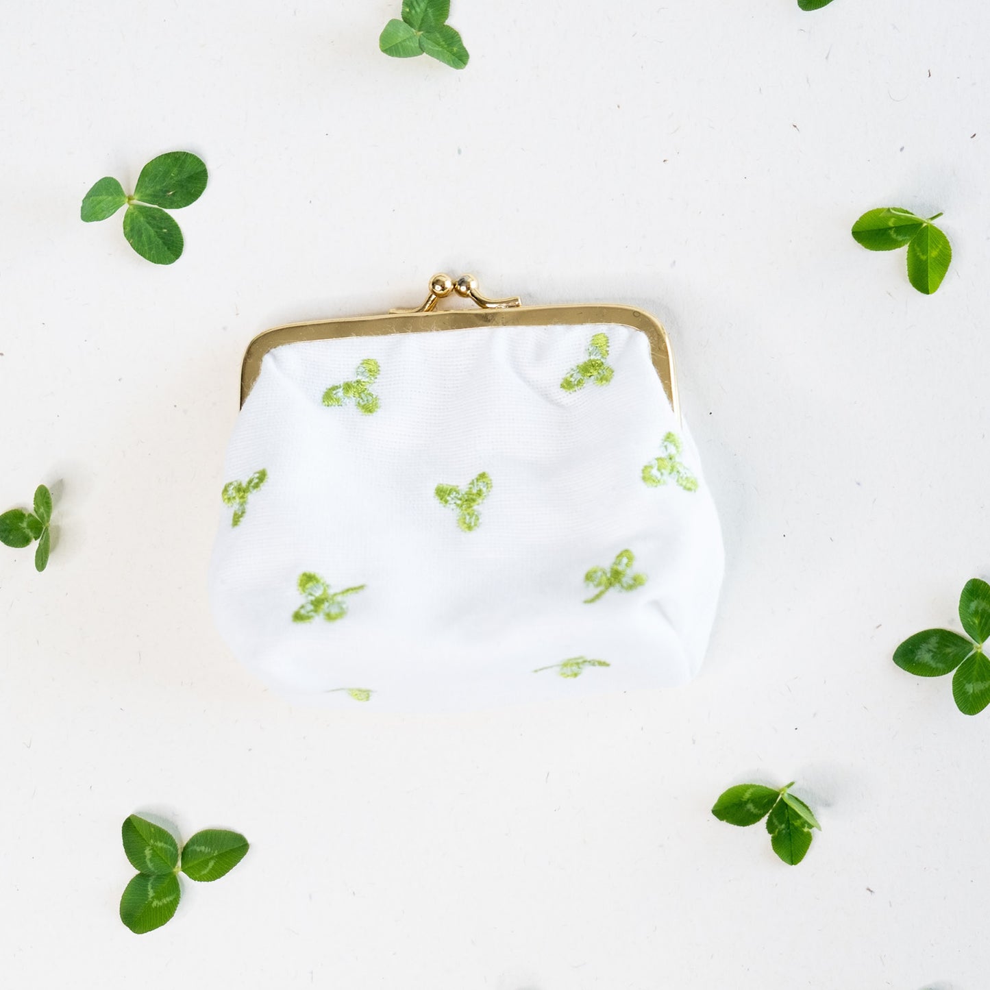 Torbica s kovinskim zapiranjem in izvezenimi deteljicami