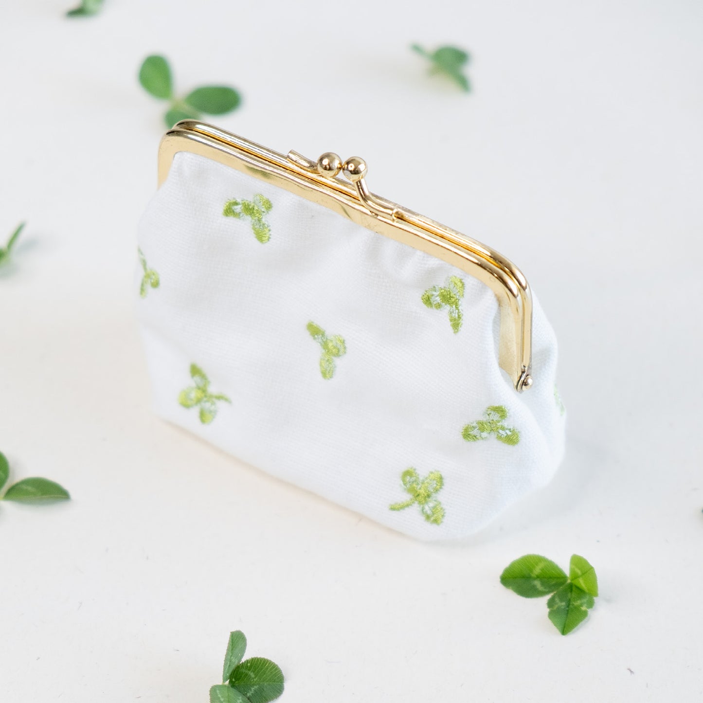 Torbica s kovinskim zapiranjem in izvezenimi deteljicami