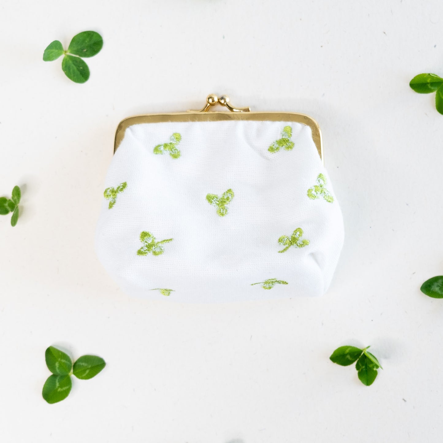 Torbica s kovinskim zapiranjem in izvezenimi deteljicami