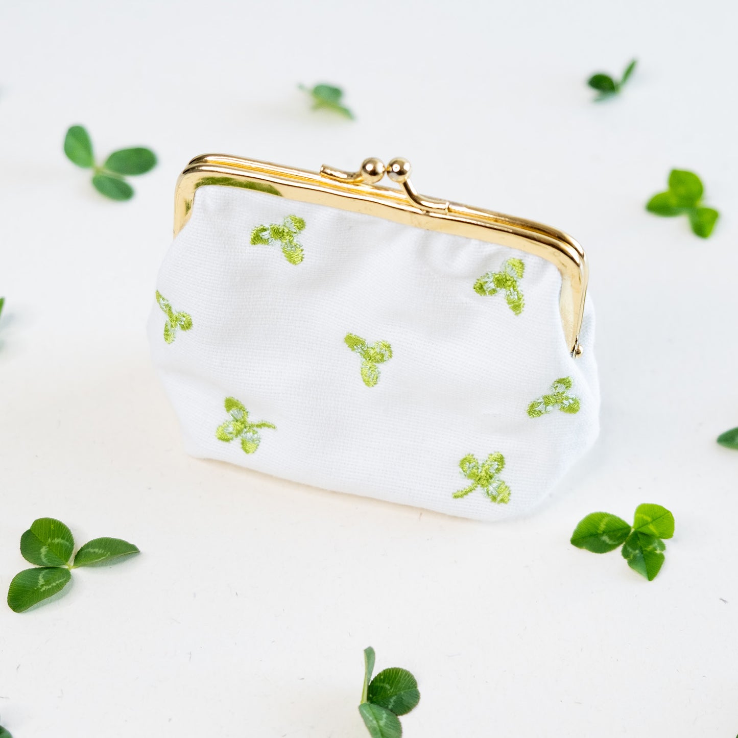 Torbica s kovinskim zapiranjem in izvezenimi deteljicami