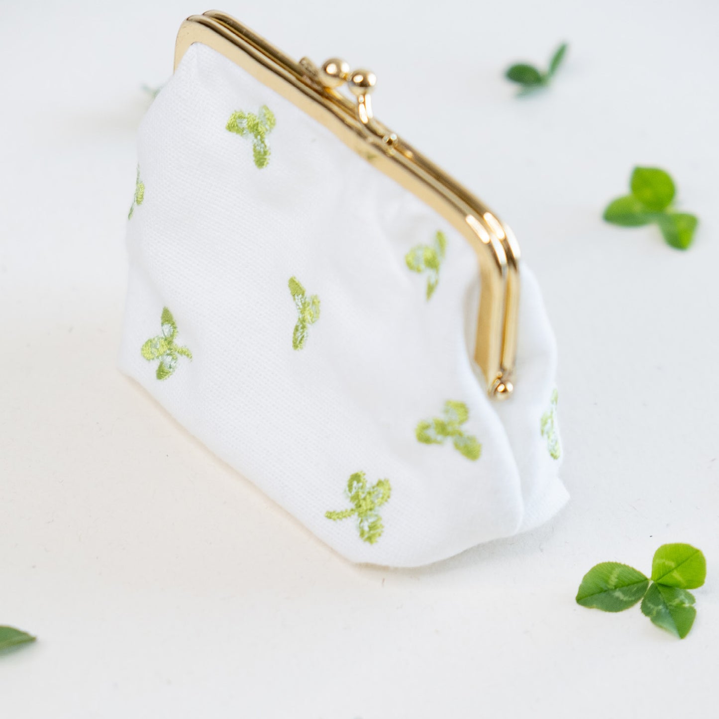 Torbica s kovinskim zapiranjem in izvezenimi deteljicami