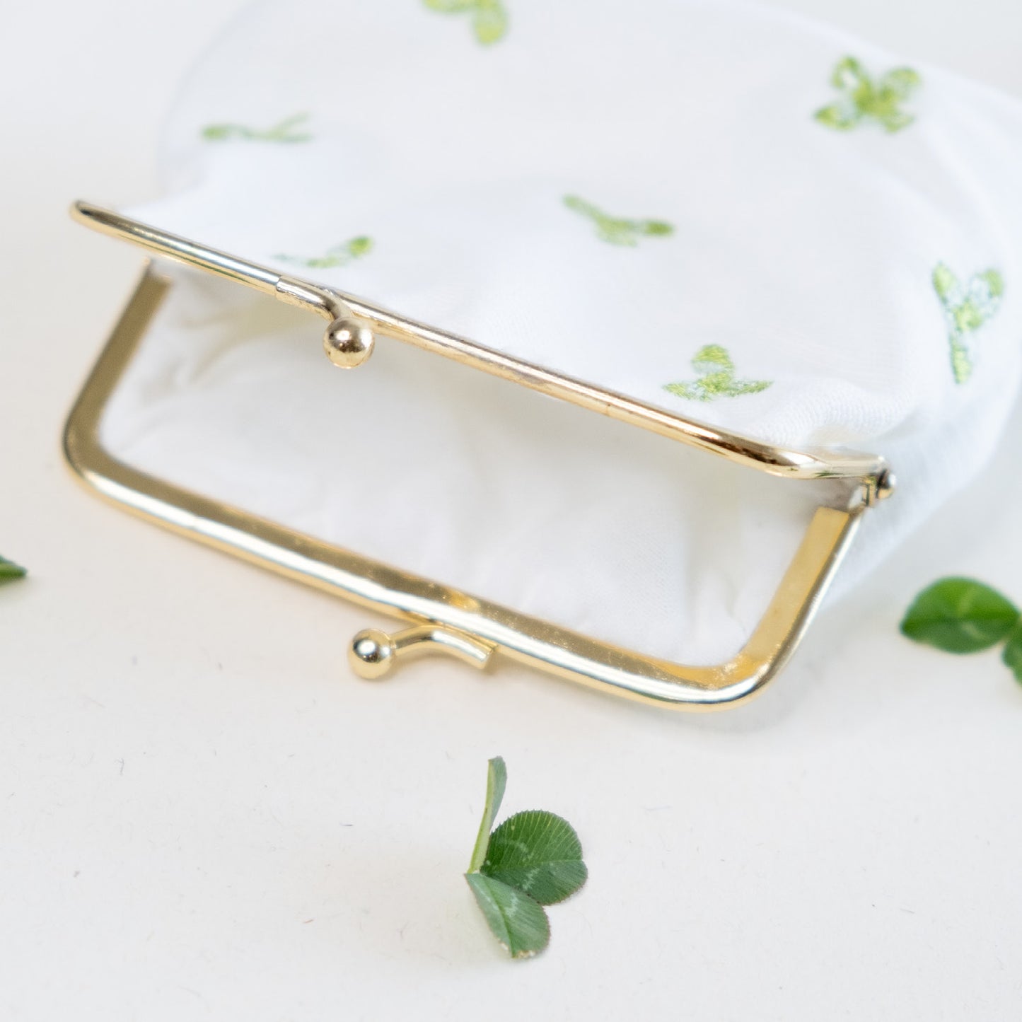 Torbica s kovinskim zapiranjem in izvezenimi deteljicami