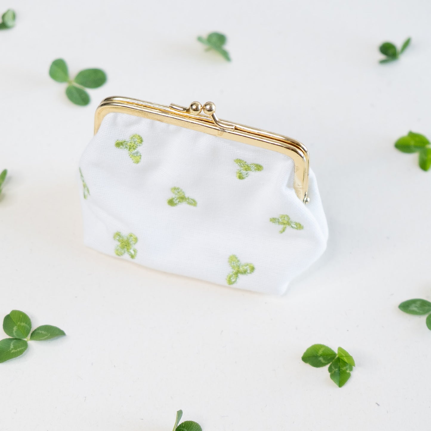 Torbica s kovinskim zapiranjem in izvezenimi deteljicami