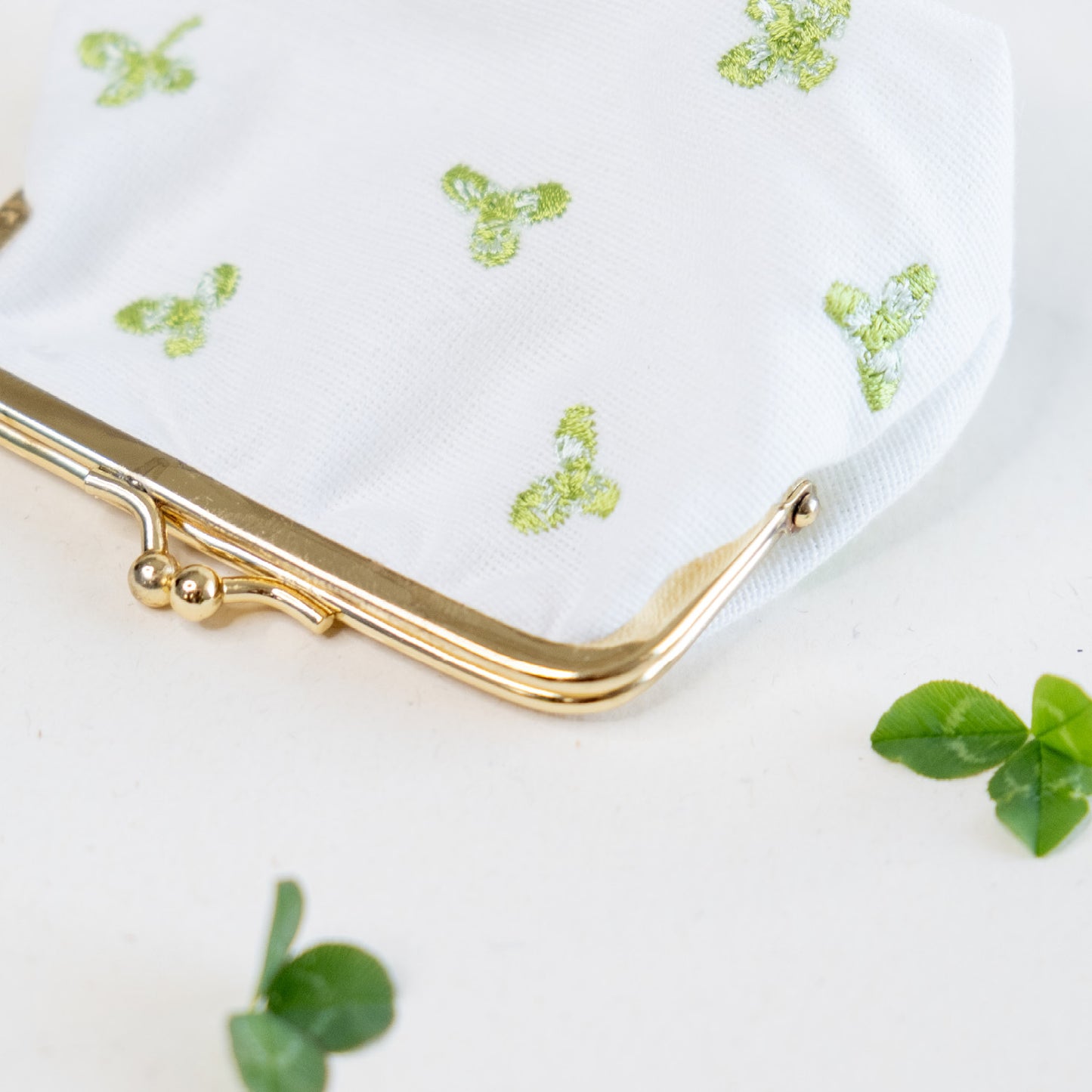 Torbica s kovinskim zapiranjem in izvezenimi deteljicami