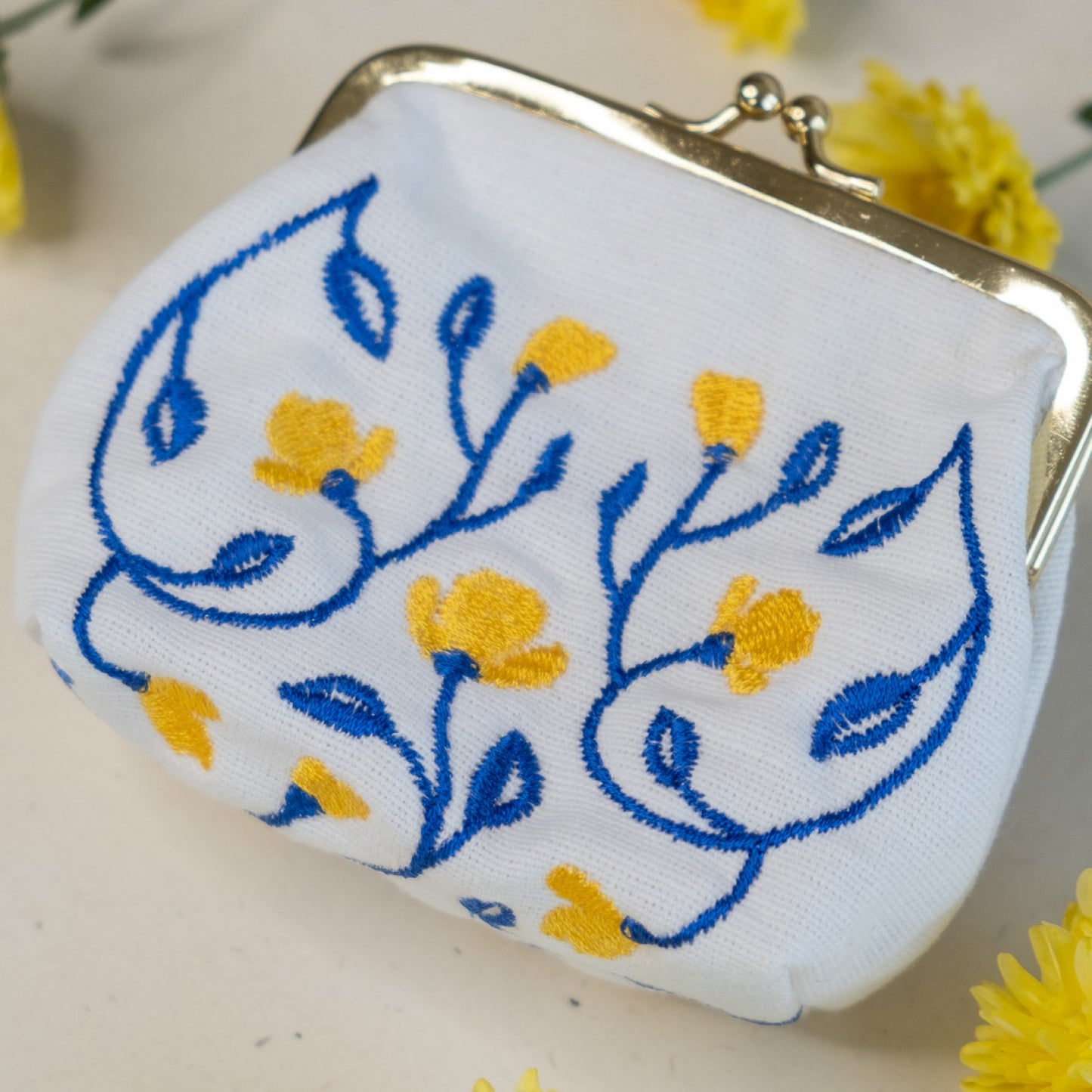 Torbica s kovinskim zapiranjem in izvezenimi cvetlicami