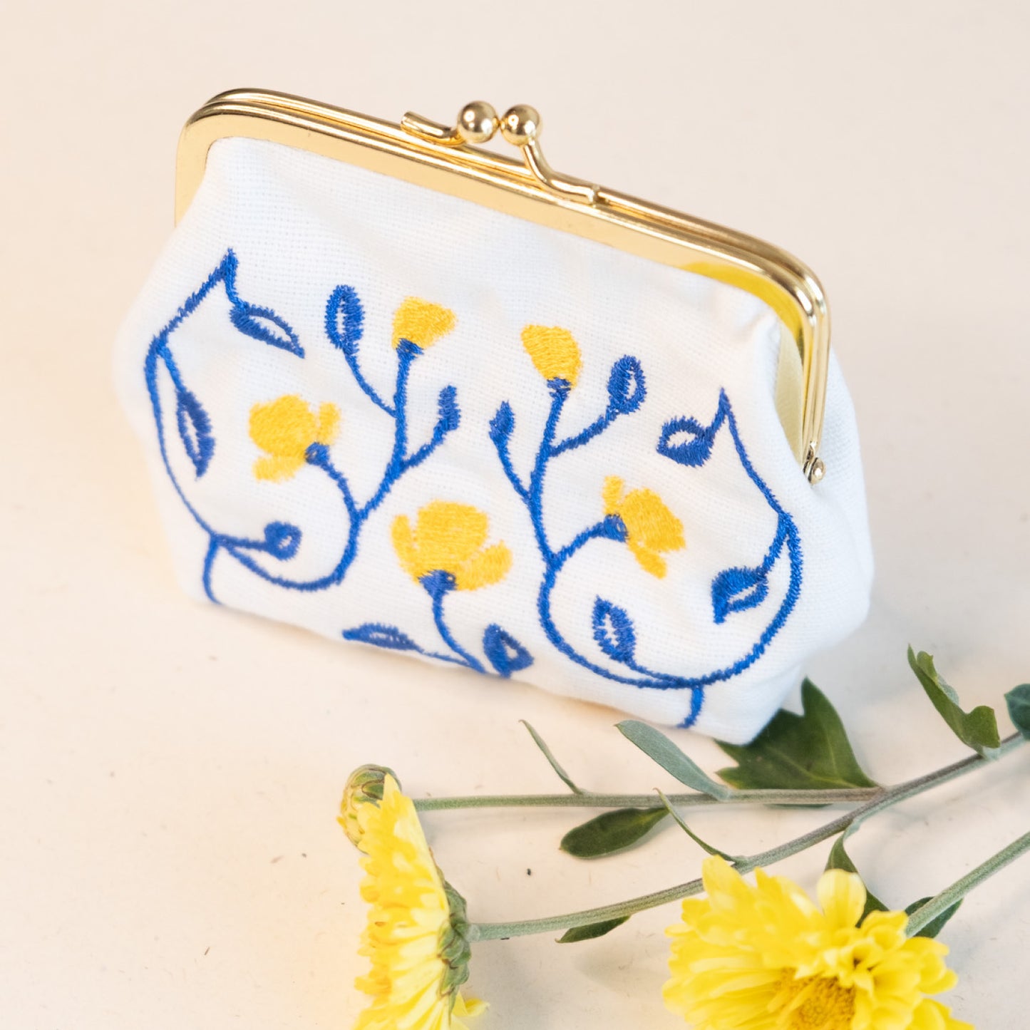 Torbica s kovinskim zapiranjem in izvezenimi cvetlicami