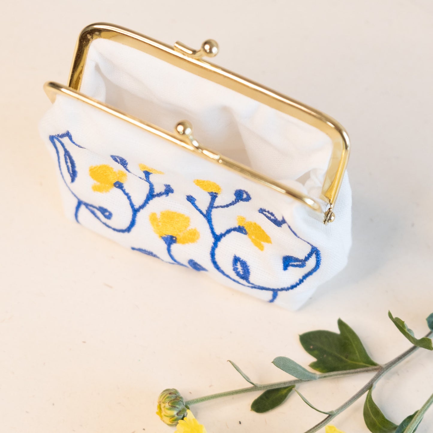 Torbica s kovinskim zapiranjem in izvezenimi cvetlicami