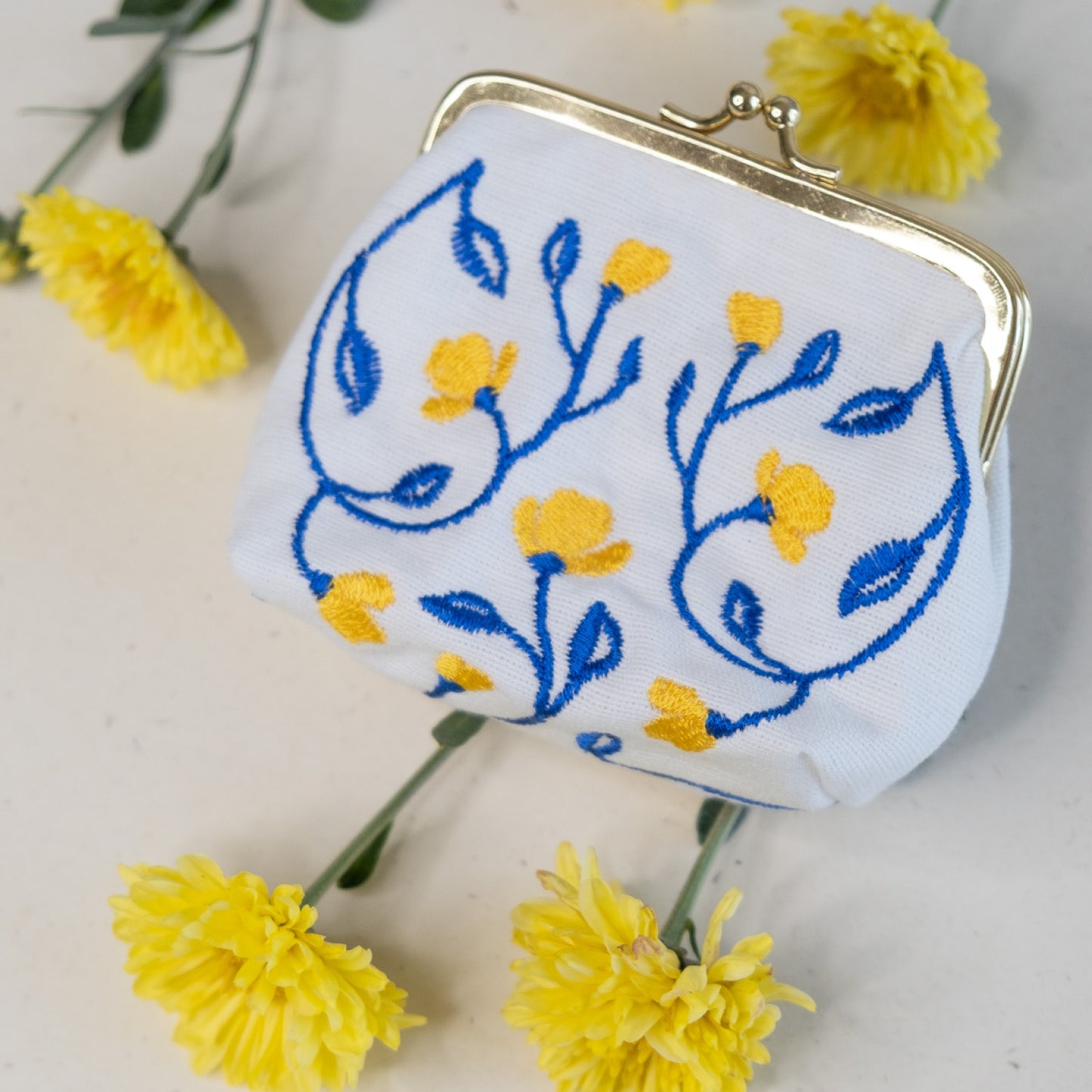 Torbica s kovinskim zapiranjem in izvezenimi cvetlicami