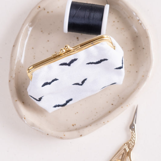 Torbica s kovinskim zapiranjem in izvezenimi netopirji