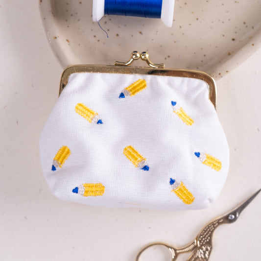 Torbica s kovinskim zapiranjem in izvezenimi svinčniki