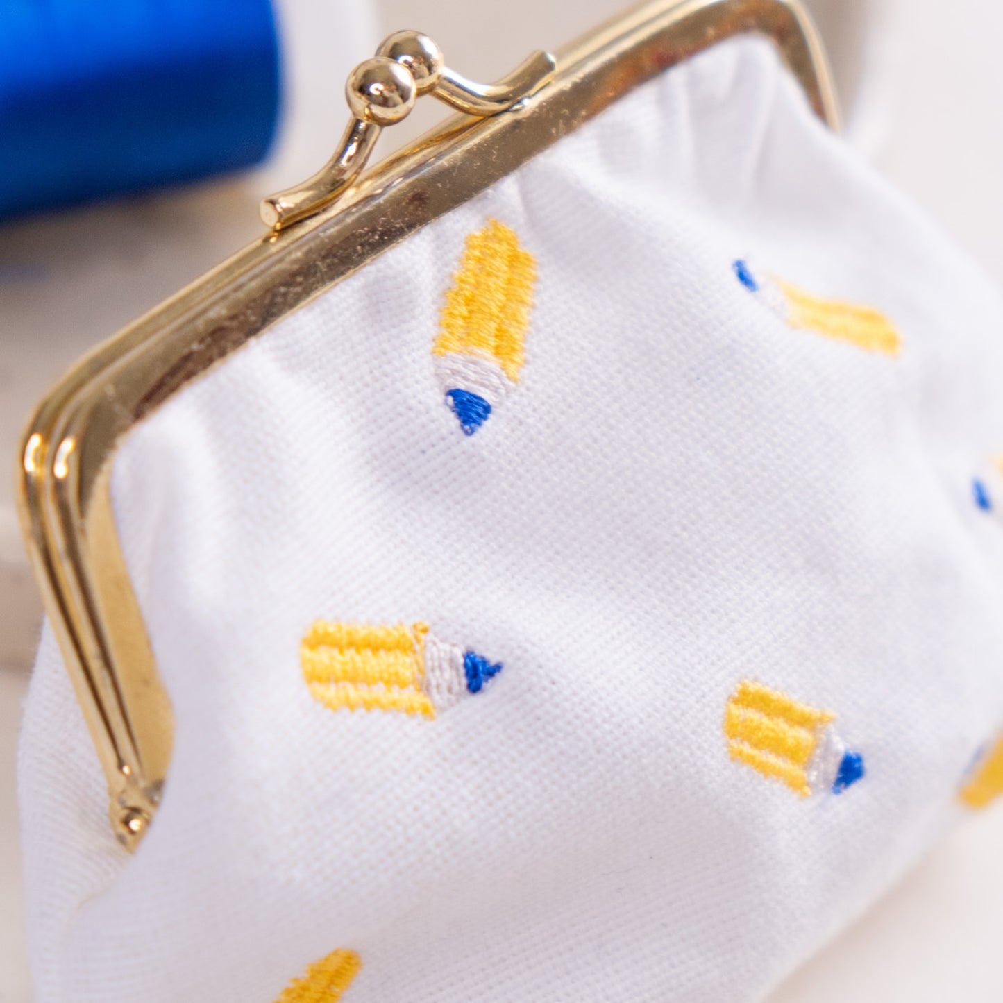 Torbica s kovinskim zapiranjem in izvezenimi svinčniki