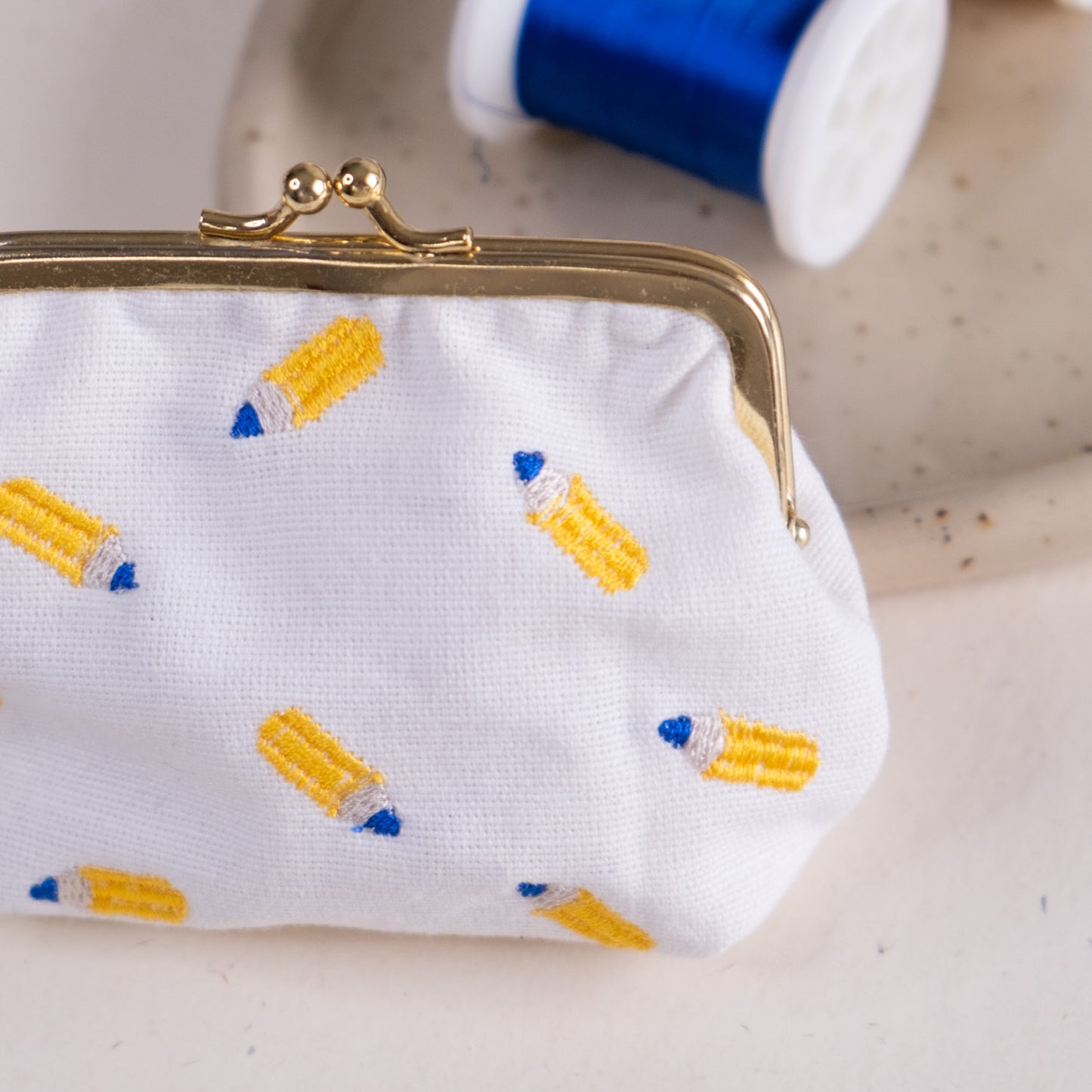 Torbica s kovinskim zapiranjem in izvezenimi svinčniki